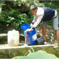 Salah seorang warga saat mengambil air di daerah perbukitan.